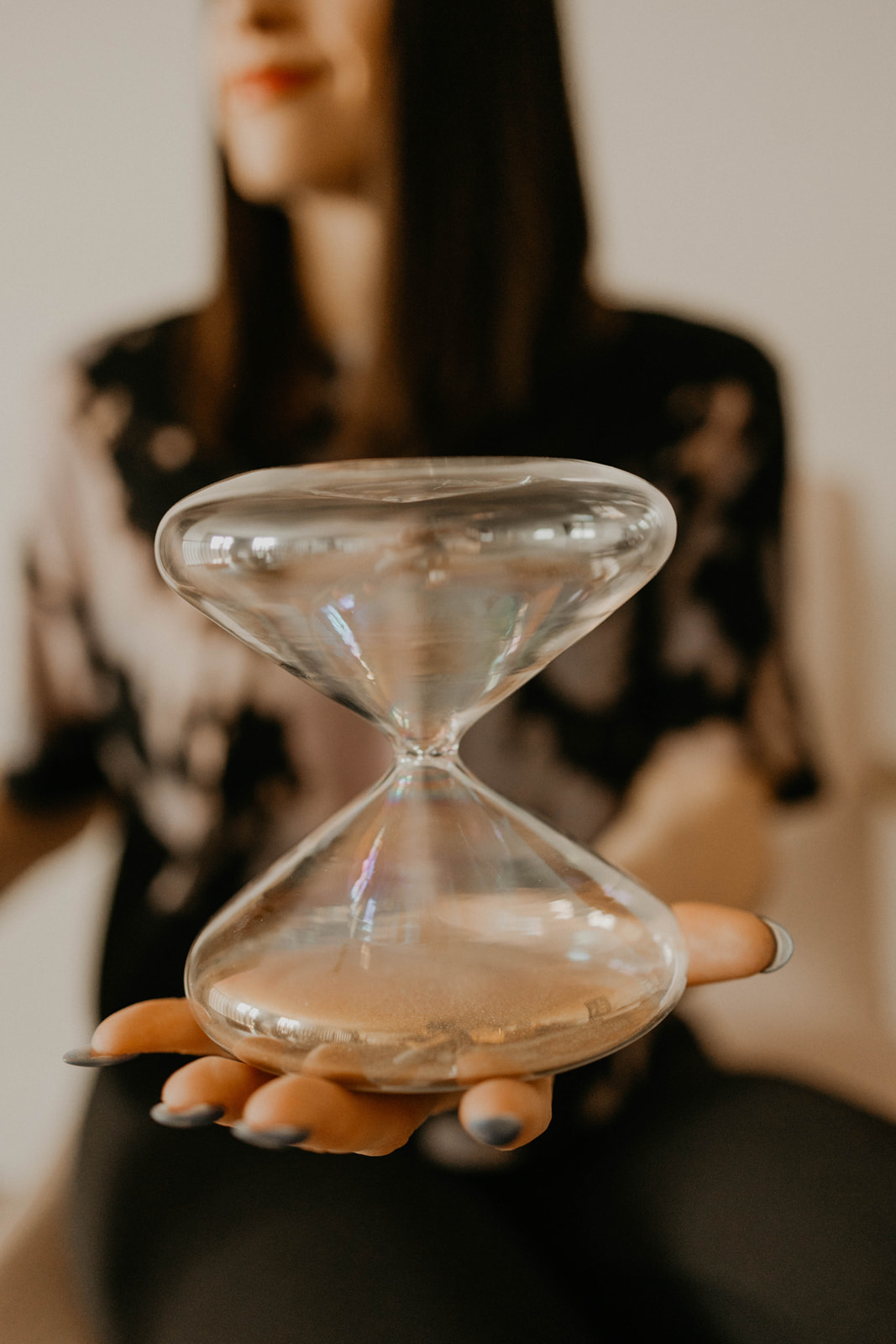 An hourglass held in an open palm.