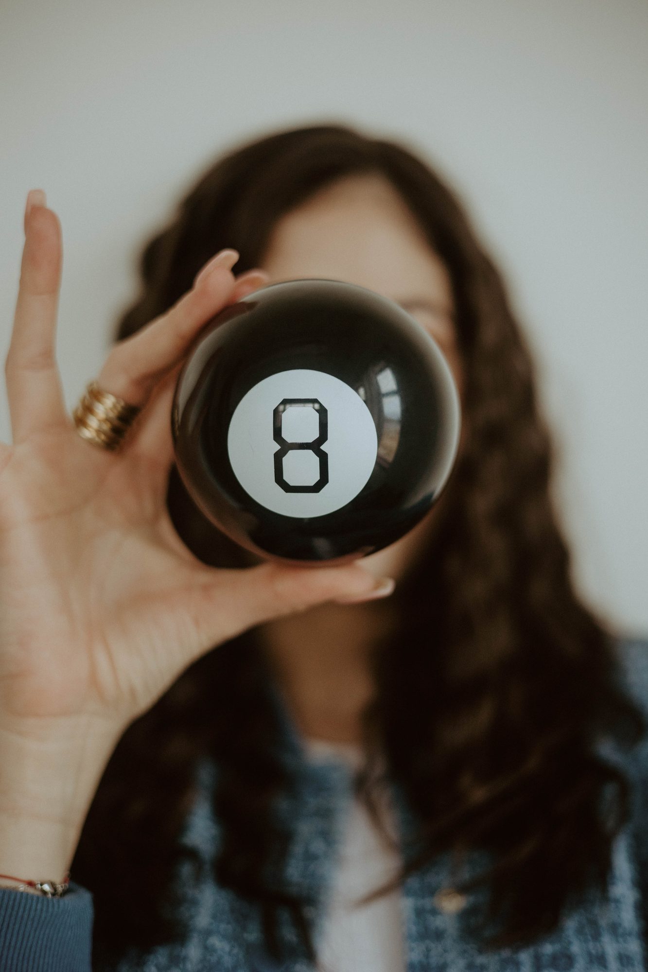 Natalie holding a magic 8 ball in front of her face.