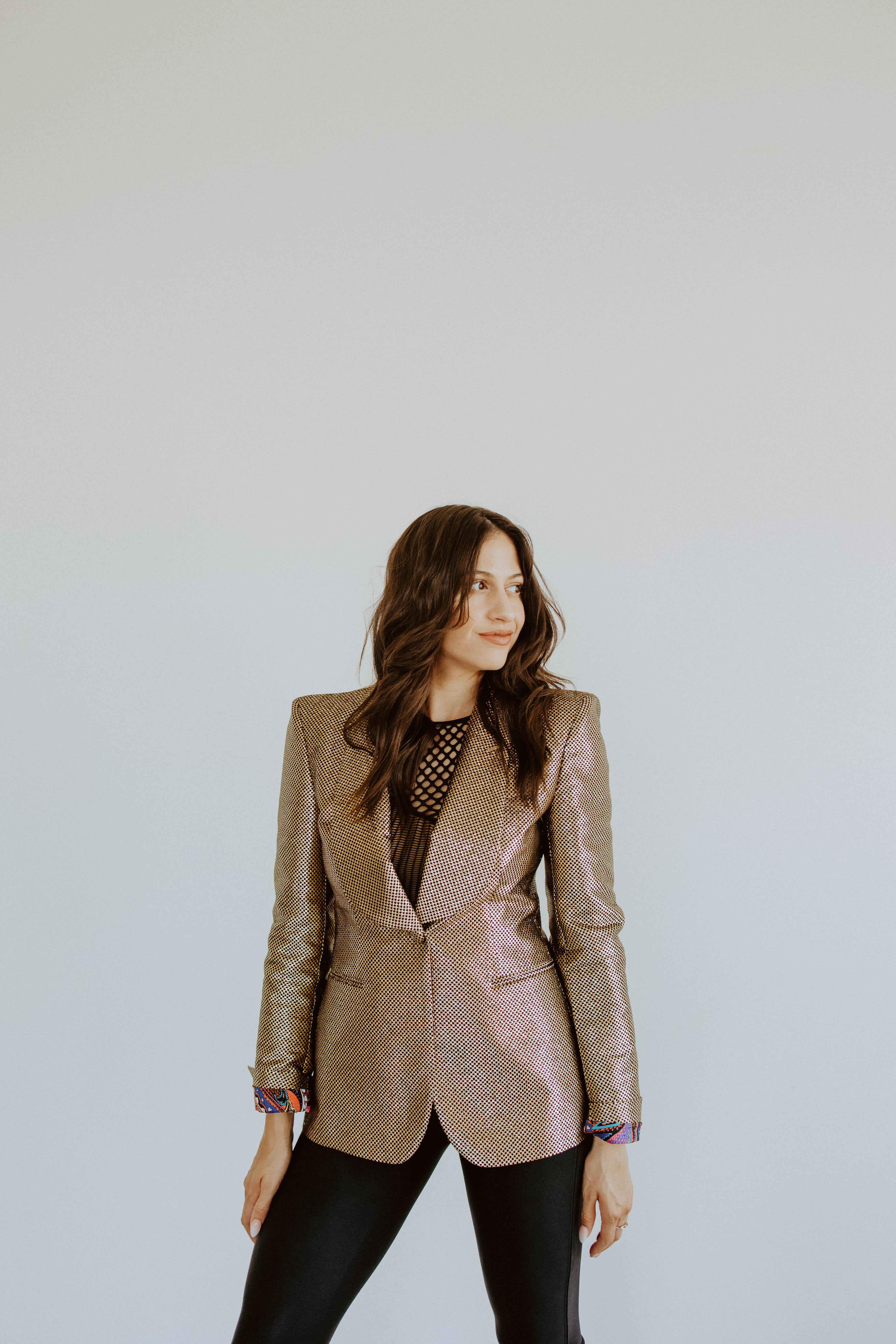 Natalie standing in a structured blazer and looking toward the next direction.