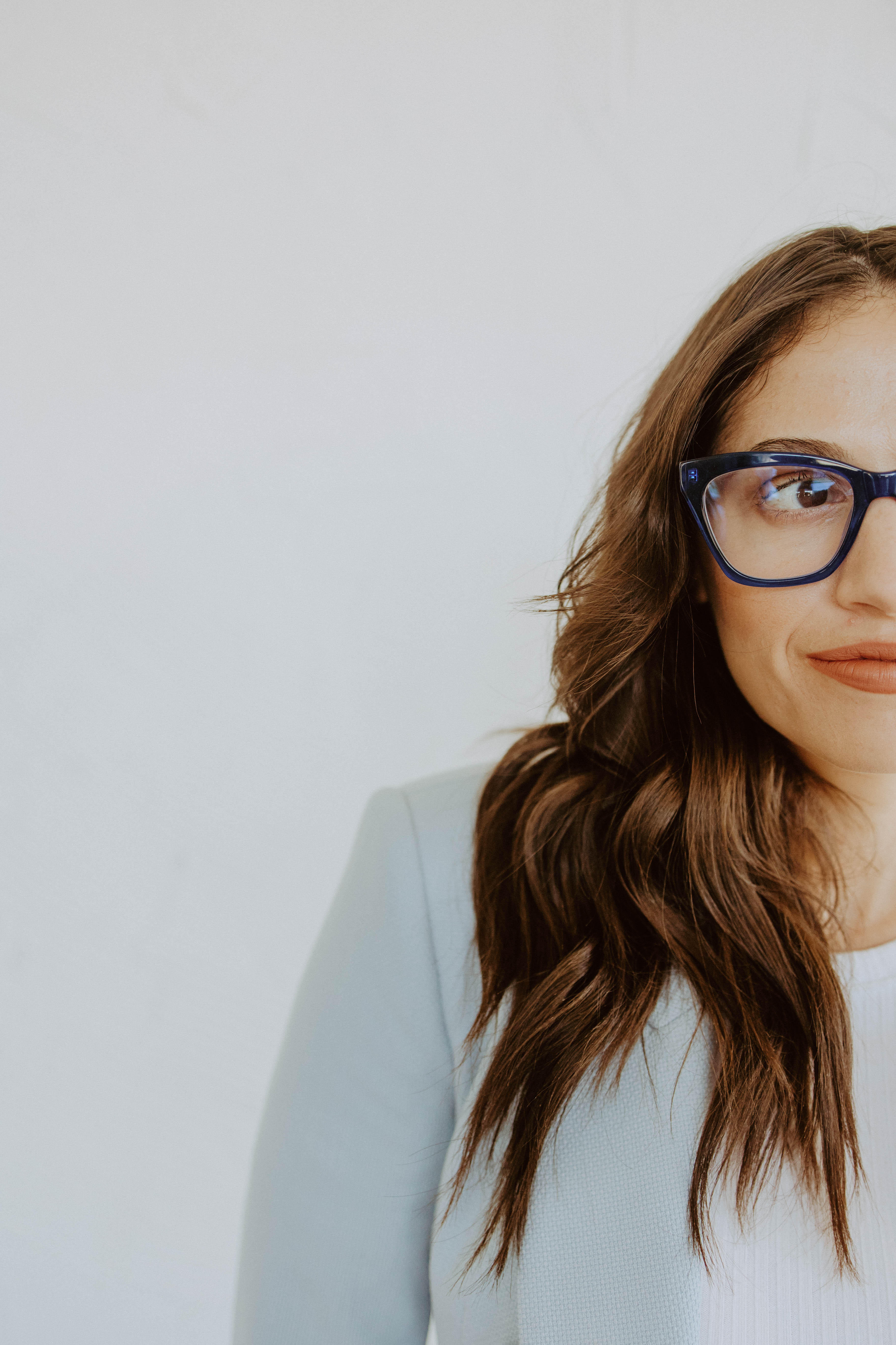 Close portrait of Natalie Micale Schultz wearing blue glasses.